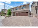 A wide, brick driveway leads to a 3-car garage in front of this two-story home at 5788 Robin Ridge Ave, Las Vegas, NV 89141