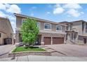Two-story home with a three-car garage, stone accents, and a landscaped front yard at 5788 Robin Ridge Ave, Las Vegas, NV 89141