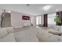 Bright living room featuring a staircase, modern decor, and large windows at 5788 Robin Ridge Ave, Las Vegas, NV 89141