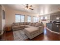 Spacious living room featuring hardwood floors, a ceiling fan, and a large sectional sofa at 7021 Salt Marsh Ct, Las Vegas, NV 89148