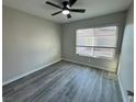 Bedroom featuring grey laminate wood flooring, ceiling fan, and window with blinds at 7144 Forest Vista St, Las Vegas, NV 89147