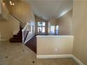 Bright living room with staircase, neutral paint, tiled entry, and large windows for natural light at 7604 Cruz Bay Ct, Las Vegas, NV 89128