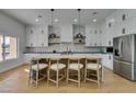 Modern kitchen featuring white cabinets, marble countertops, stainless steel appliances, and a stylish island with seating at 8713 Litchfield Ave, Las Vegas, NV 89134