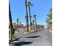 View of the community entrance with palm trees; access controlled via secure gate at 9470 Peace Way # 212, Las Vegas, NV 89147