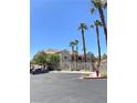 Exterior view of condo buildings with palm trees, landscaping, parking, and access gates at 9470 Peace Way # 212, Las Vegas, NV 89147