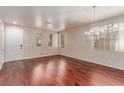Spacious living room featuring hardwood floors, a decorative chandelier, and an abundance of natural light at 10584 Peach Creek St, Las Vegas, NV 89179