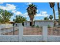 Cozy home featuring a white brick fence, desert landscaping and tall palms at 1804 David Ave, Las Vegas, NV 89101