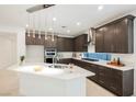 Modern kitchen with sleek cabinetry, stainless steel appliances, and a stylish pendant lighting fixture at 19 Desert Ivy Ln, Henderson, NV 89011