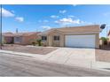 Single-story house with a two-car garage and desert landscaping at 2111 Hollow Oak Ave, North Las Vegas, NV 89031