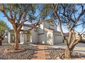 Two-story home with mature trees, a red tile roof, and a well-maintained front yard at 2204 W San Miguel Ave, North Las Vegas, NV 89032