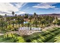 Aerial view of Rhodes Ranch community showcasing lush landscaping, palm trees and a lake feature at 261 Fairway Woods Dr, Las Vegas, NV 89148