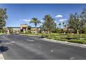 Community entrance featuring decorative stonework, lush landscaping, and well-maintained roadways at 261 Fairway Woods Dr, Las Vegas, NV 89148