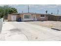 Single-story home with long driveway, gravel front yard, and mature trees nearby at 2616 Spear St, North Las Vegas, NV 89030