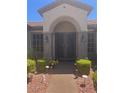 Close-up of a stylish front entrance showcasing a decorative security door and manicured landscaping at 2695 Olivia Heights Ave, Henderson, NV 89052