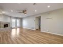 A spacious living room with wood floors, fireplace, ceiling fan, and french doors at 2785 Carnation Ln # 0, Henderson, NV 89074