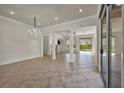 Open living space with tile flooring, chandelier lighting, columns, and sliding doors leading to the patio at 37 Stonemark Dr, Henderson, NV 89052