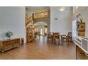 Sun-filled living room with hardwood floors, soaring ceilings, and an open staircase leading to the second floor at 6109 Sandstone Mesa Dr, Las Vegas, NV 89130