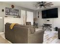 Comfortable living room with a white brick fireplace, ceiling fan, and wood-look flooring at 6441 Brushwood Ln, Las Vegas, NV 89107