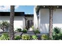 Modern home entrance with sleek black trim and lush landscaping at 645 Dragon Peak Dr, Henderson, NV 89012