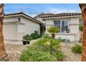 Quaint single-story home with desert landscaping, including palm trees and decorative garden art at 703 Jane Eyre Pl, Henderson, NV 89002