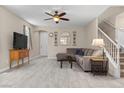 Inviting living room with tile flooring, neutral walls, ceiling fan, and staircase at 7818 Brodie Castle Ct, Las Vegas, NV 89166