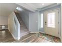 Bright entryway with a staircase, wood-look floors, a decorative rug, and a front door with glass panes at 8484 Montana Stream Ave, Las Vegas, NV 89113