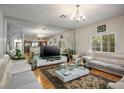 Bright living room featuring hardwood floors and a large decorative mirror wall at 9357 Golden Timber Ln, Las Vegas, NV 89117