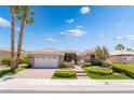Inviting single story home with a well-manicured lawn and brick driveway under a bright blue sky at 10331 Rio De Thule Ln, Las Vegas, NV 89135
