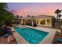 Relaxing pool with lounge area and palm trees under a colorful evening sky at 10331 Rio De Thule Ln, Las Vegas, NV 89135