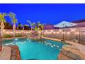 Inviting backyard pool features a rock waterfall feature and tropical landscaping at 1717 Jake Andrew Ave, North Las Vegas, NV 89086