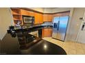 Compact kitchen with stainless steel appliances, granite countertops, and maple cabinetry at 211 E Flamingo Rd # 405, Las Vegas, NV 89169