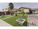 Lush front yard features artificial grass, mature palm trees, and a brick driveway at 2112 Los Altos St, Las Vegas, NV 89102