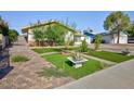Landscaped front yard with artificial grass, mature trees, desert plants, and brick-paved walkway at 2112 Los Altos St, Las Vegas, NV 89102
