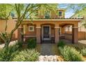 Two-story home featuring a covered porch, desert landscaping, and a charming facade at 2385 Via Firenze, Henderson, NV 89044