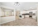 A spacious open-concept kitchen with stainless steel appliances and white cabinetry at 2385 Via Firenze, Henderson, NV 89044