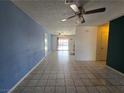 Spacious living room features tile flooring, ceiling fan, neutral paint and flows into the kitchen at 256 Winona Ter, Henderson, NV 89015