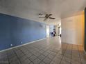 Open living room boasts neutral walls, tile floors, ceiling fan, and easy access to the kitchen at 256 Winona Ter, Henderson, NV 89015