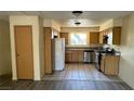 Bright kitchen features wood cabinets, stainless steel appliances, tile floors, and a window with a view at 3412 Mercury St # I, North Las Vegas, NV 89030