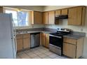 Updated kitchen features stainless steel appliances, granite countertops, wood cabinets and tile floors at 3412 Mercury St # I, North Las Vegas, NV 89030