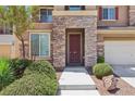 Inviting two-story home featuring stone accents and mature landscaping leading to the front door at 3609 Kingfishers Catch Ave, North Las Vegas, NV 89084