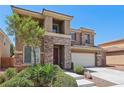 Two-story home featuring stone accents, a two-car garage, and mature landscaping at 3609 Kingfishers Catch Ave, North Las Vegas, NV 89084