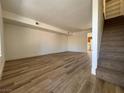 Bright living room boasts wood-look floors and staircase access to the upper level of the home at 453 Las Casitas Way, Las Vegas, NV 89121