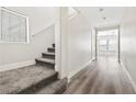 Bright hallway with staircase, hardwood floors and view to the living room with multiple windows at 5824 Gemstone Peak St, North Las Vegas, NV 89031