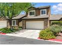 Inviting two-story home with a two-car garage, mature tree, and well-maintained landscaping at 620 Painted Cloud Pl, Las Vegas, NV 89144