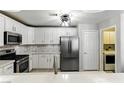 Well-lit kitchen featuring white cabinets, stainless steel appliances, and modern backsplash at 620 Painted Cloud Pl, Las Vegas, NV 89144