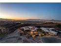 Expansive aerial view of a modern property on a hilltop, offering panoramic views of the Las Vegas skyline at 720 Dragon Peak Dr, Henderson, NV 89012
