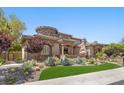 Beautiful stucco single-Gathering home featuring lush landscaping, a stone accent, and manicured lawn at 73 Kittansett Loop, Henderson, NV 89052