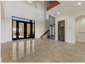 Grand foyer with decorative iron doors, marble floors, and soaring ceilings offers a luxurious entrance at 73 Kittansett Loop, Henderson, NV 89052