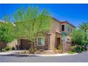 Two-story home featuring stone accents, a two-car garage, and a well-manicured front yard with mature trees at 7733 Harthill Park Ave, Las Vegas, NV 89113