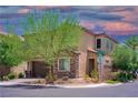 Two-story home featuring stone accents, a two-car garage, and a well-manicured front yard with mature trees at 7733 Harthill Park Ave, Las Vegas, NV 89113